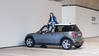 Artwork The Wait by Elmgreen & Dragset with a boy sitting on top of a Mini Cooper.