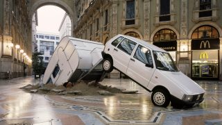 Elmgreen & Dragset artwork where a Fiat Punto caravan has crashed an italian public square in Milan.