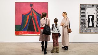 kolme museokävijää näyttelytilassa katselemassa Tal R:n maalausta.